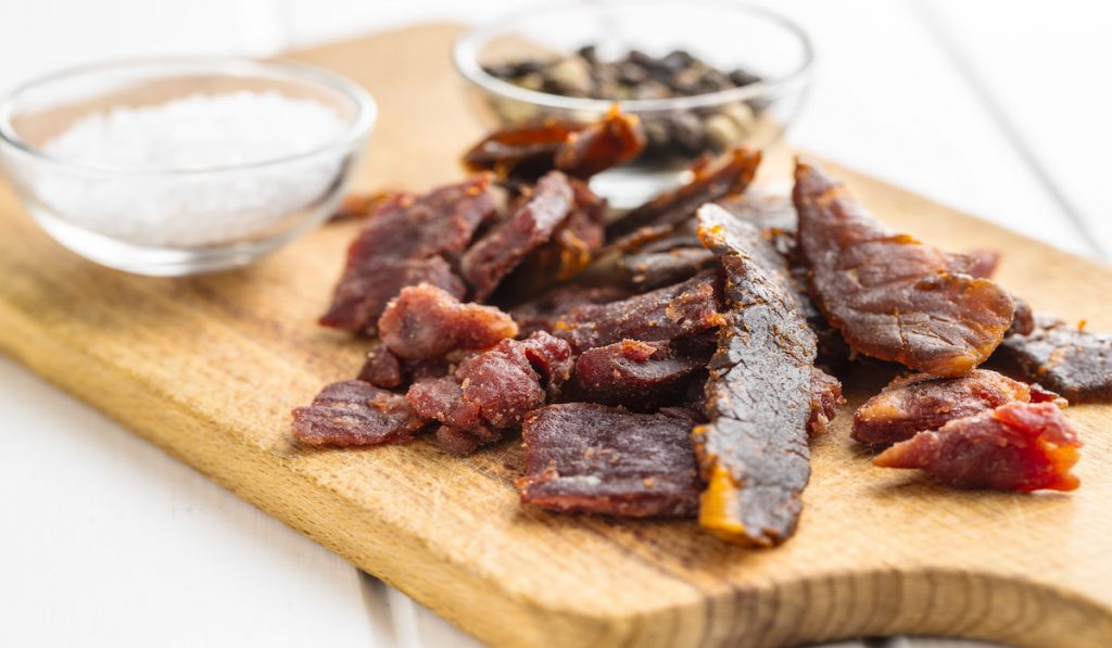 pieces of beef jerky on a wooden board