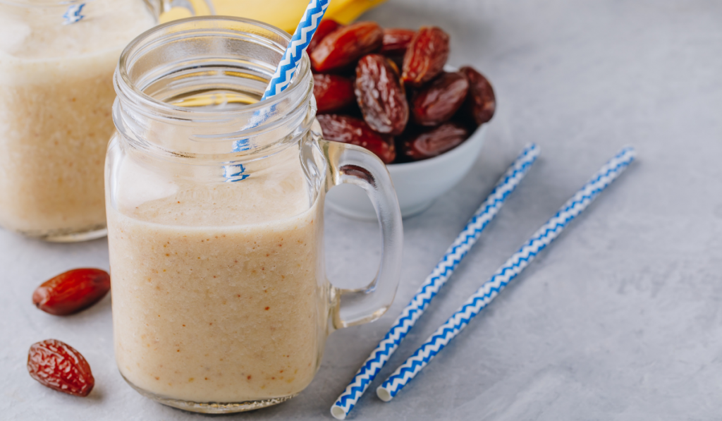 Banana and date fruit smoothie or milkshake in glass mason jar