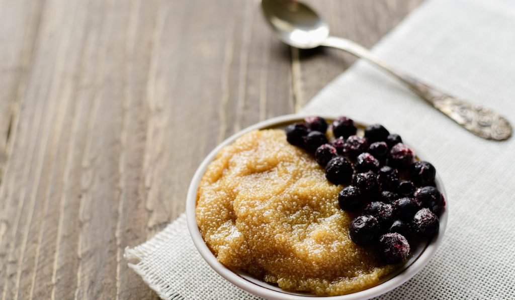 Bowl of amaranth porridge with black berries 