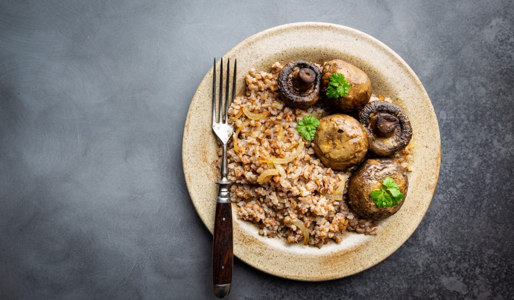 Buckwheat porridge with mushrooms on a plate with fork