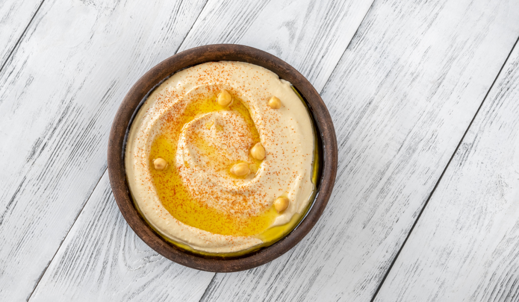 Hummus on a brown bowl on the table