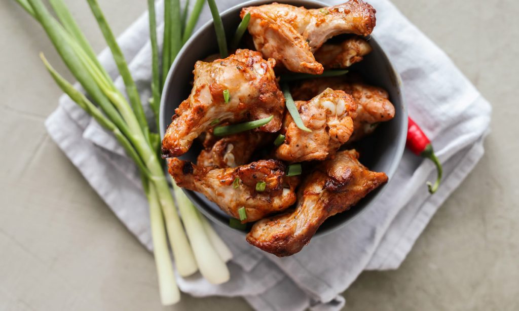 fried chicken legs on a bowl with lemon grass 