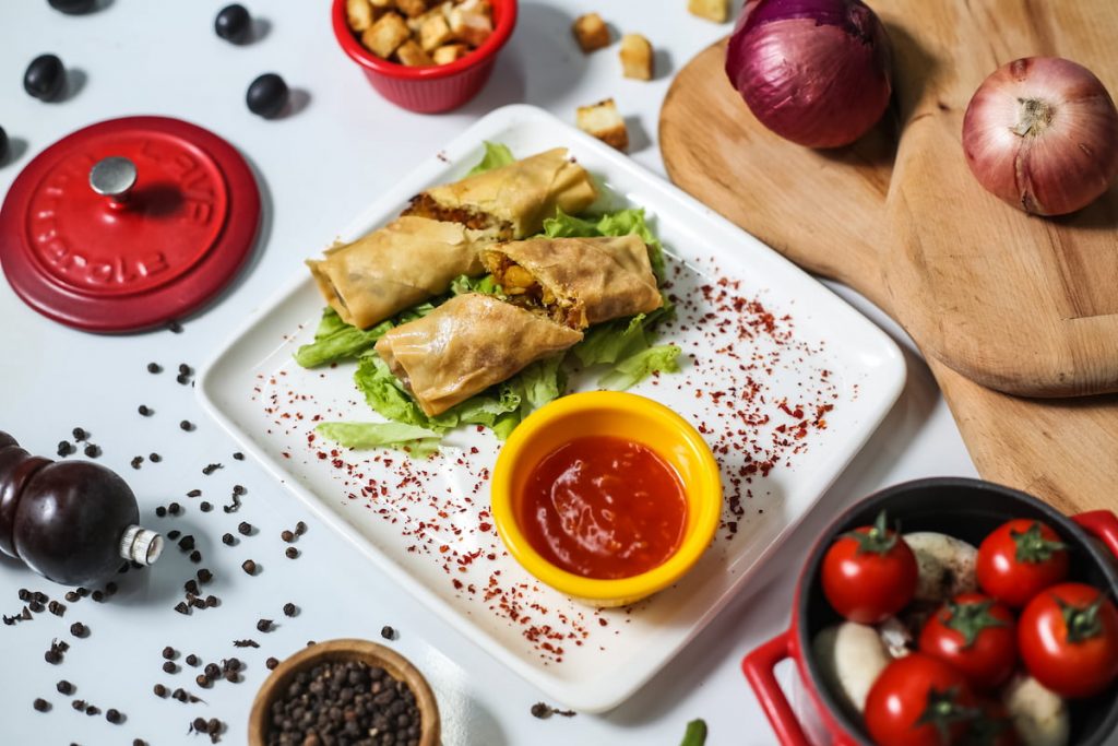 ketchup on a plate with tomatoes and onions on the table