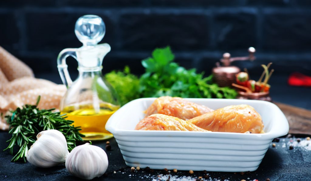 marinated fried chicken with oil garlic thyme on table