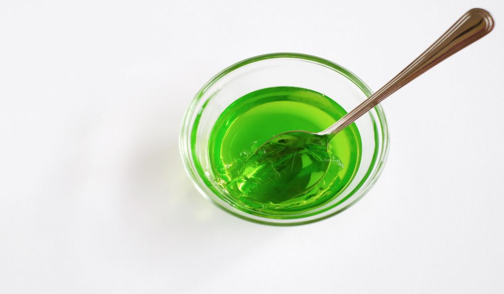 small bowl with green jello with a spoon