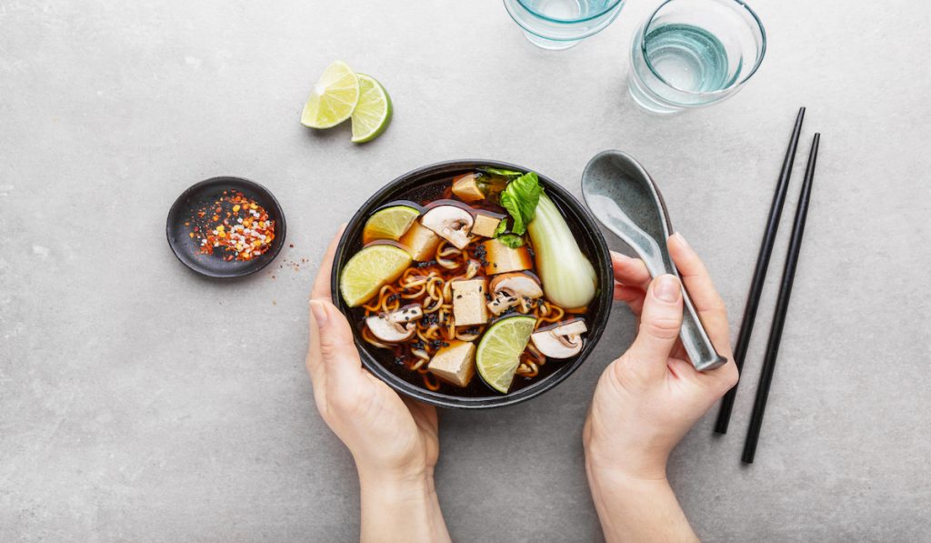 woman eating tofu vegetarian soup 