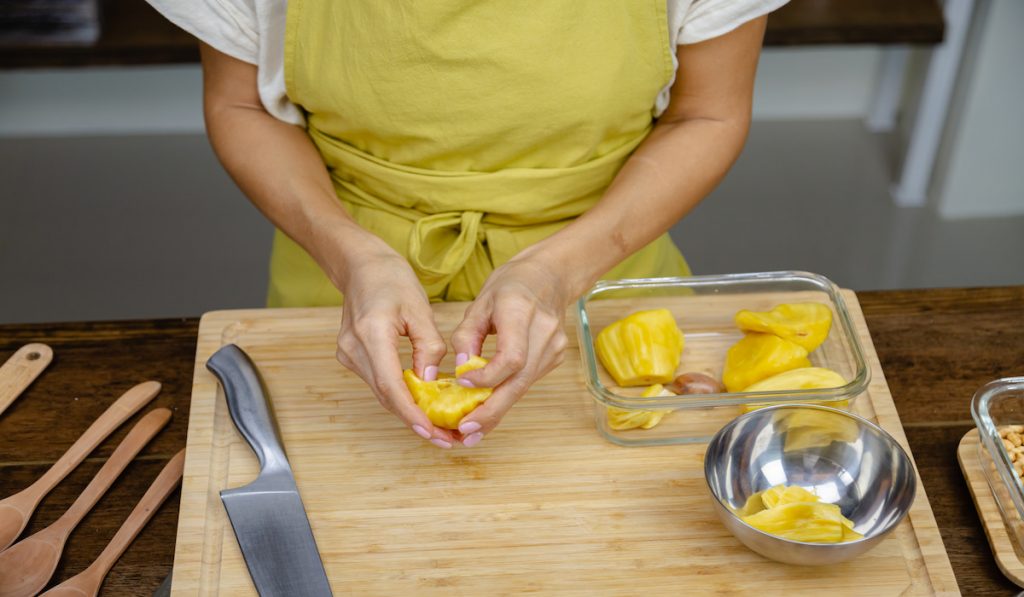 woman taking the seeds out of the jackfruit