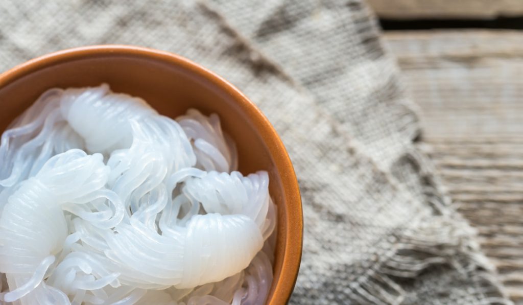 Bowl of shirataki noodles on wooden table